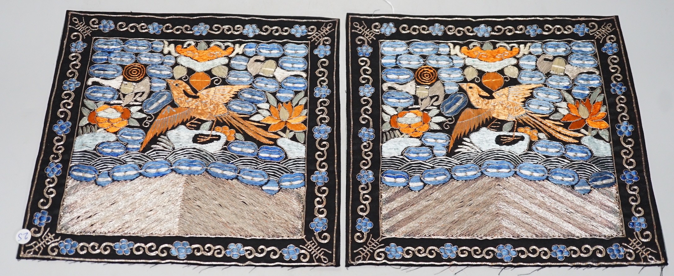 Two Chinese 20th century Chinese rank badges, embroidered I’m metal and coloured silk threads on a black ground, with a central Phoenix surrounded by auspicious symbols, 27cms x 25cms